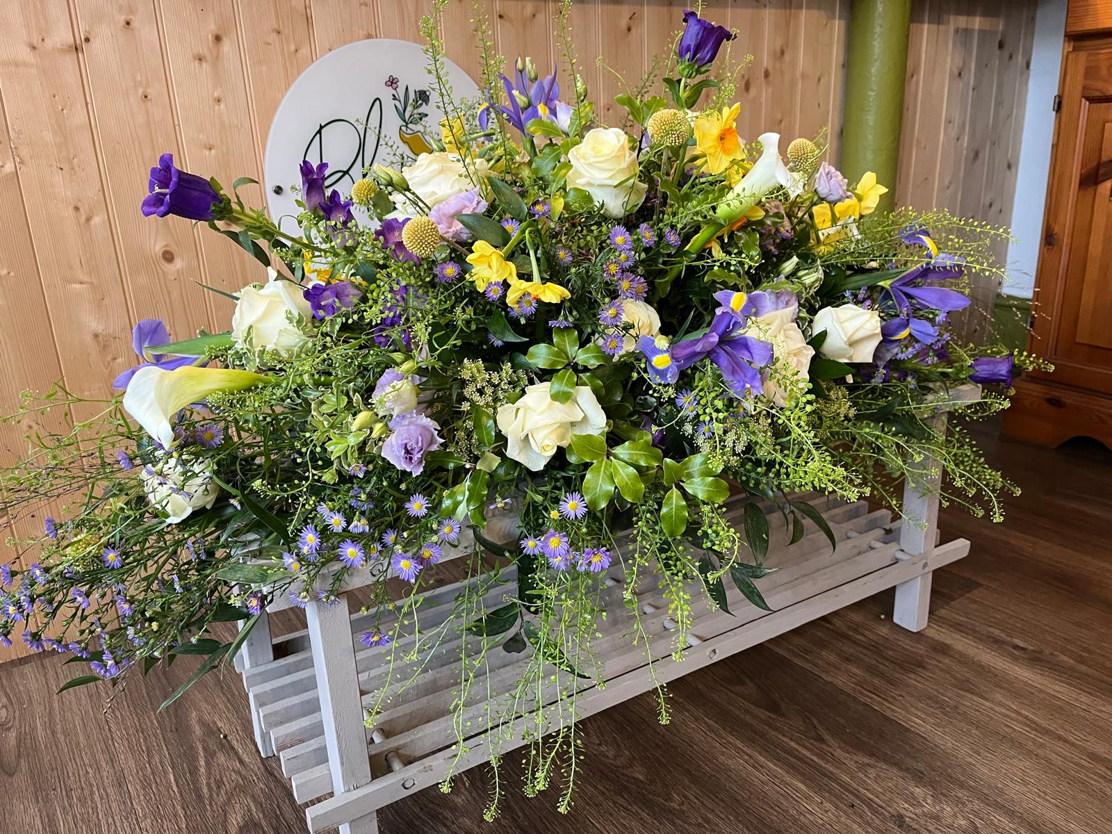 Bloemist casket spray with lilac, white and yellow flowers and natural greenery