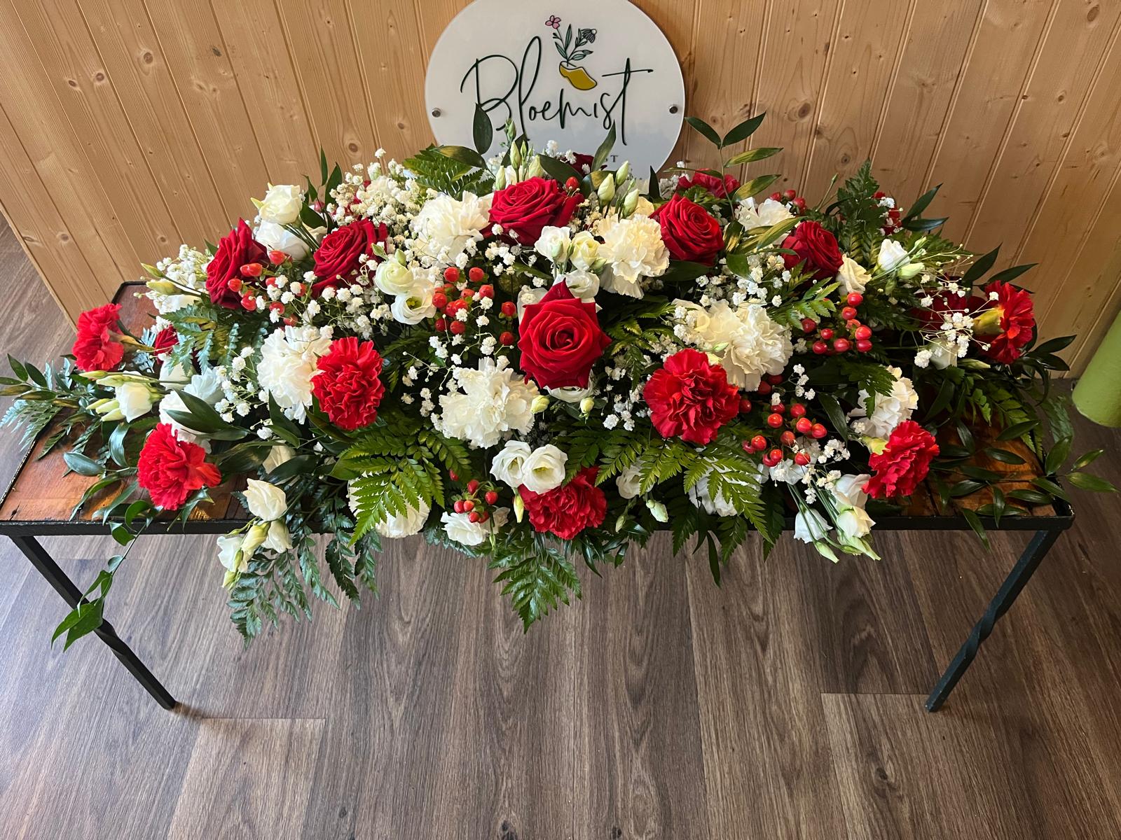 A red rose and white flower casket spray