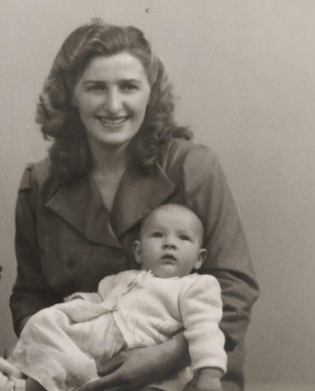 A black-and-white family photograph of a woman holding a baby