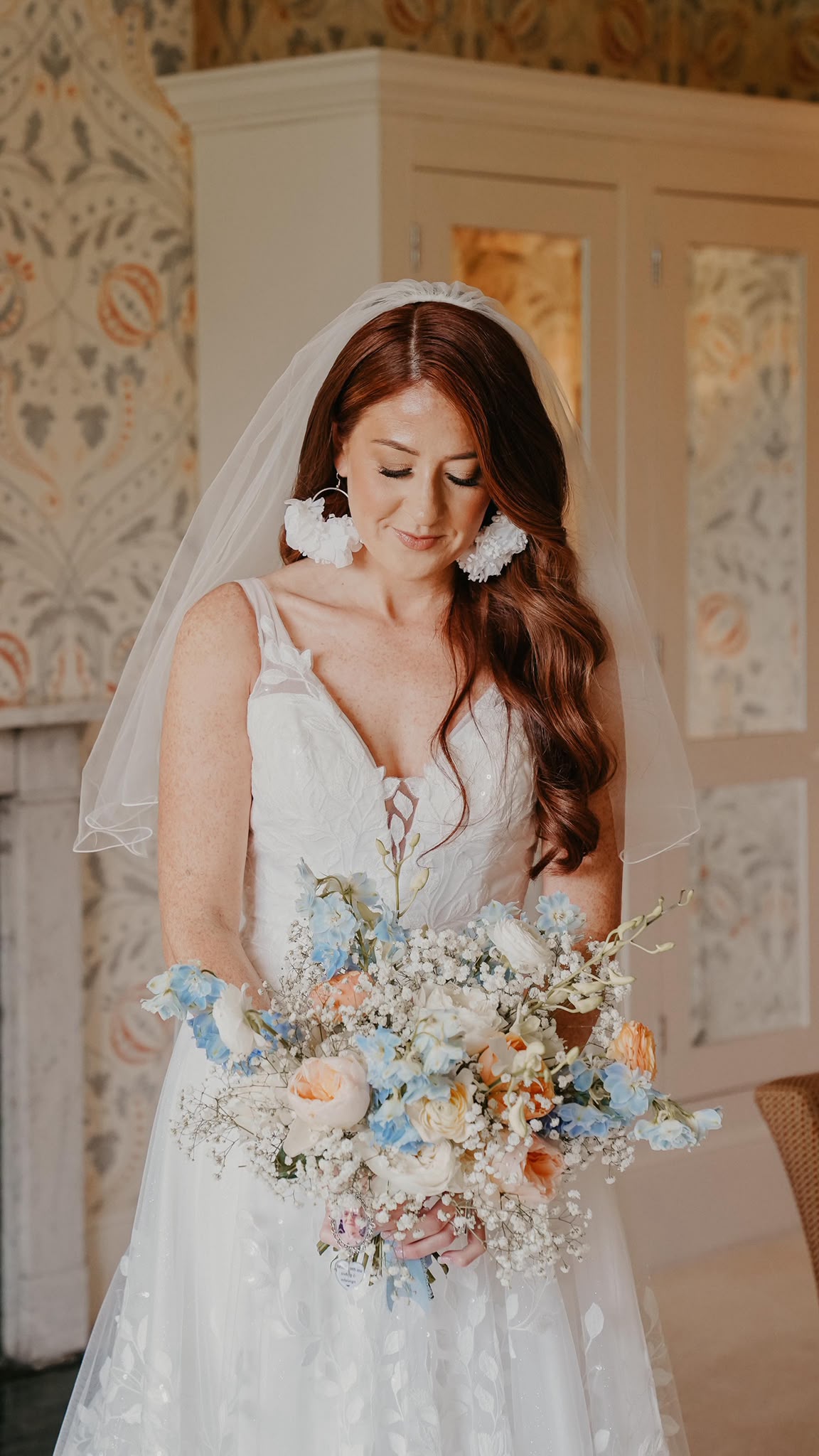 A bride holding a soft blue and white wedding bouquet