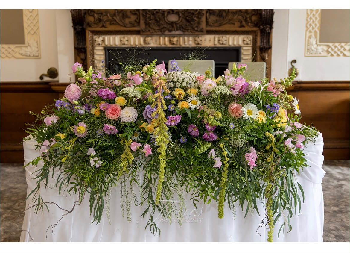 An abundant Bloemist wedding arrangement with pink, lilac, yellow and white garden flowers